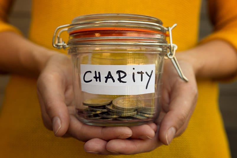 glass jar with coins that says charity on it