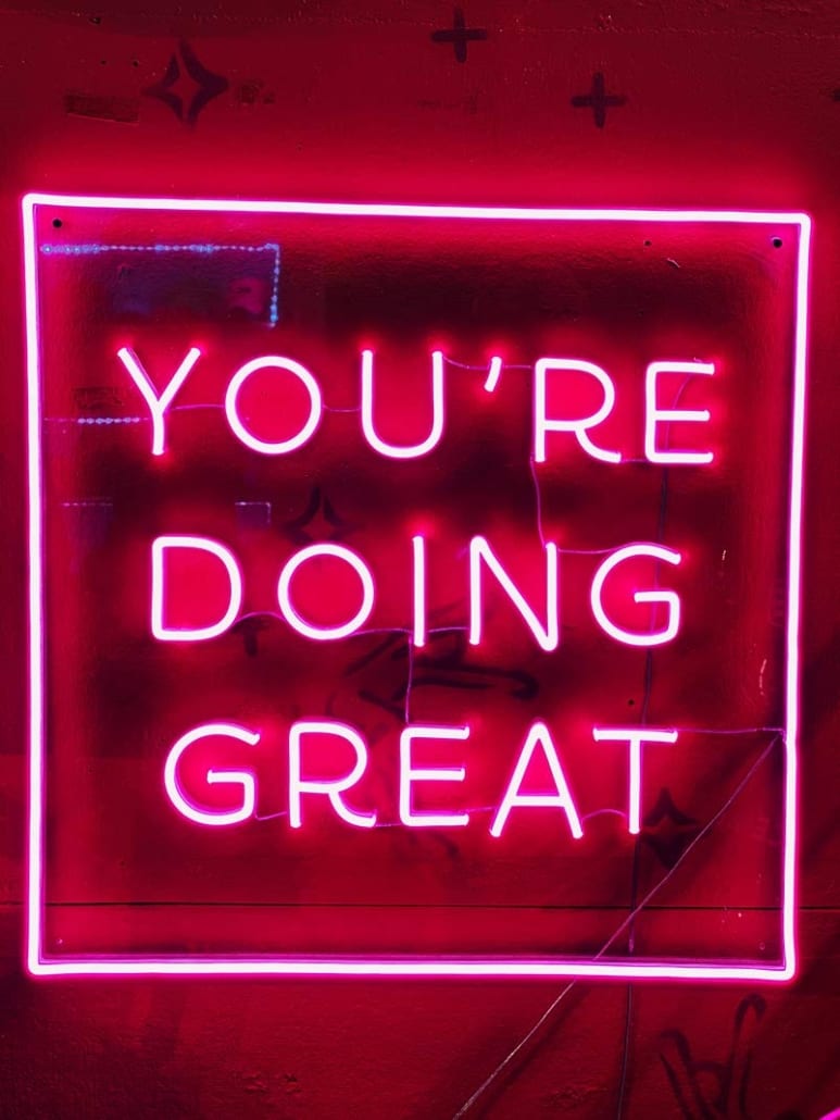 pink neon sign that says "you're doing great"