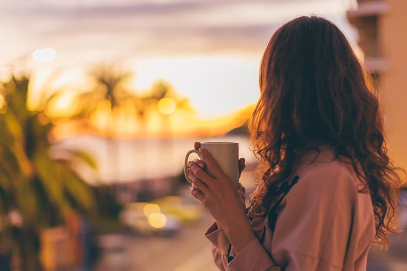 Woman taking a moment with coffee in the morning; a moment of self-care and self-compassion