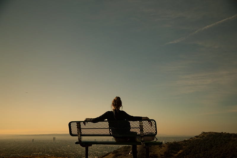 woman sitting alone on bench