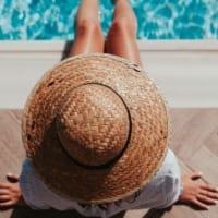 woman in straw hat at edge of pool