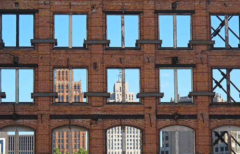 Old brick warehouse with reflection of the skyline it the windows.