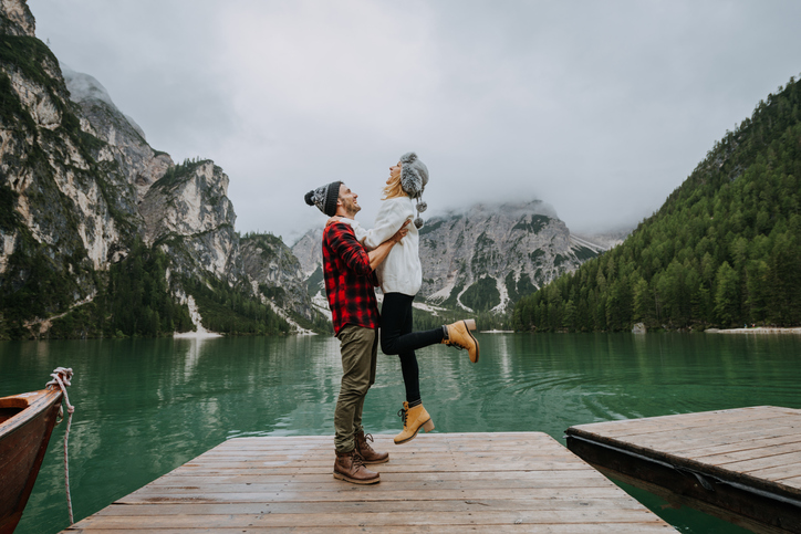 A couple celebrating their love near the mountains and water.