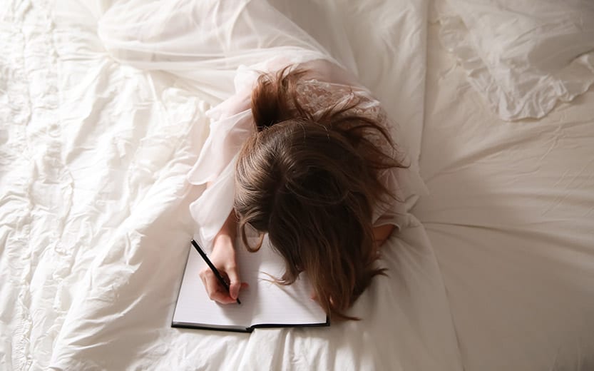 woman journaling in bed