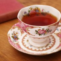 rose colored tea cup with book