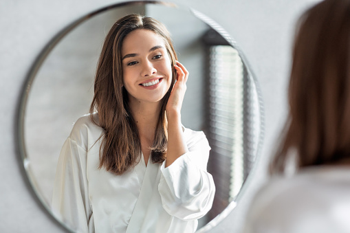 Woman smiling at herself in mirror