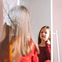 Young girl looking in mirror