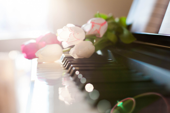 Tulips on piano. Concept of romantic music, notes, gift with flowers.